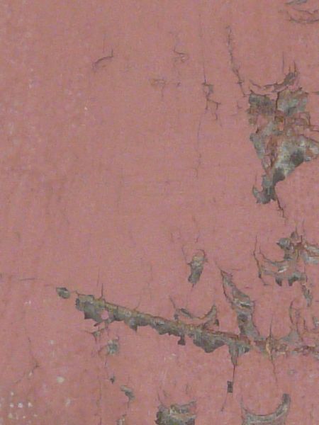 Red plywood texture made up of three chipped and cracked boards, with wood brown and grey wood visible underneath the paint.